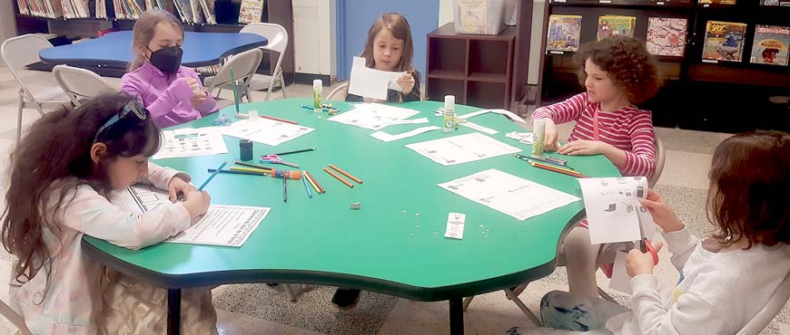 Rose et Rayan, élèves de de la 3e année établissent une liste d'engagement en faveur de l'environnement.